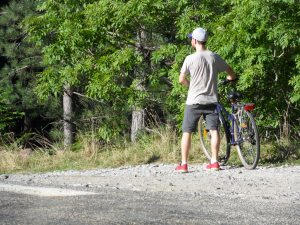 Homme de dos tenant un vélo